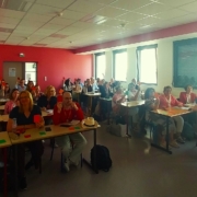 People voting in a classroom with red, orange or green cards,